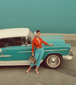 woman leaning against 1950s car