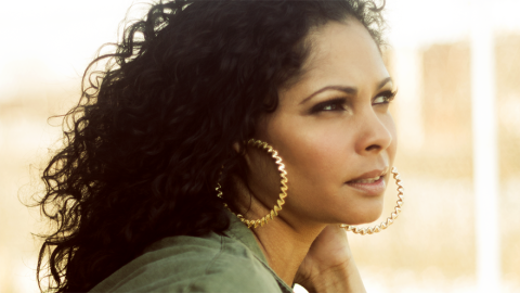Woman with large hoop earrings and wavy black hair