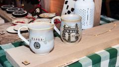Hand thrown pottery mugs featuring Elora landmarks for sale from a vendor at the Christmas Market. 